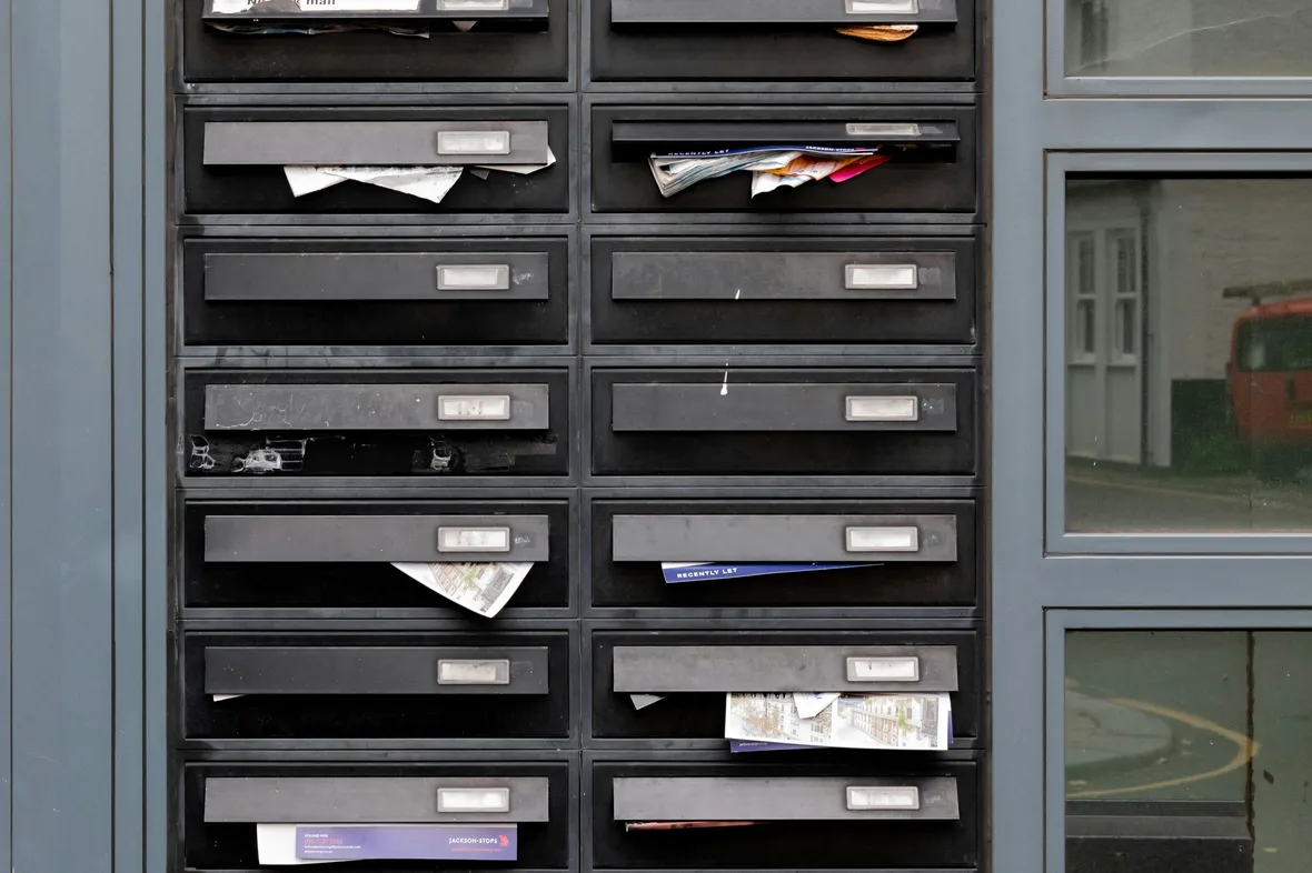 A row of mailboxes packed to overflowing